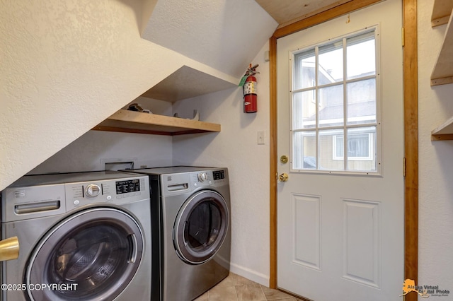 laundry area featuring light tile patterned floors and washing machine and clothes dryer