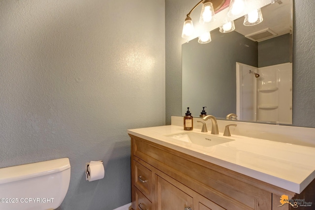 bathroom featuring walk in shower, vanity, and toilet