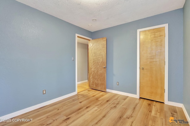 unfurnished bedroom featuring a textured ceiling and light wood-type flooring