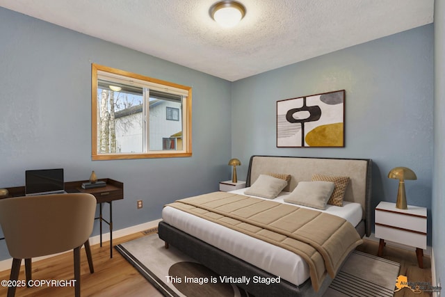 bedroom with hardwood / wood-style flooring and a textured ceiling