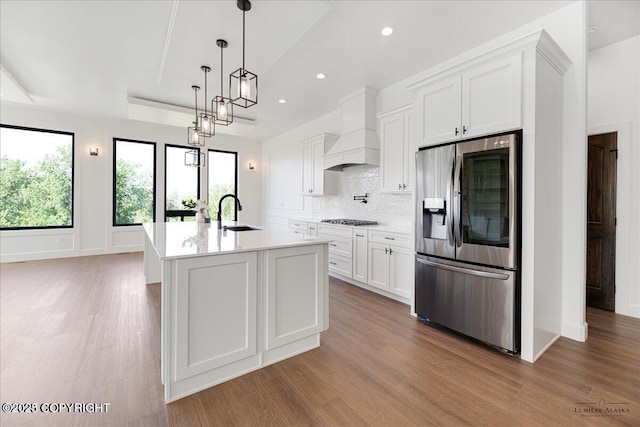 1690 W Valley Ridge Dr, Wasilla, AK 99654 - kitchen featuring stainless steel fridge, premium range hood, black cooktop, light wood-style floors, and recessed lighting
