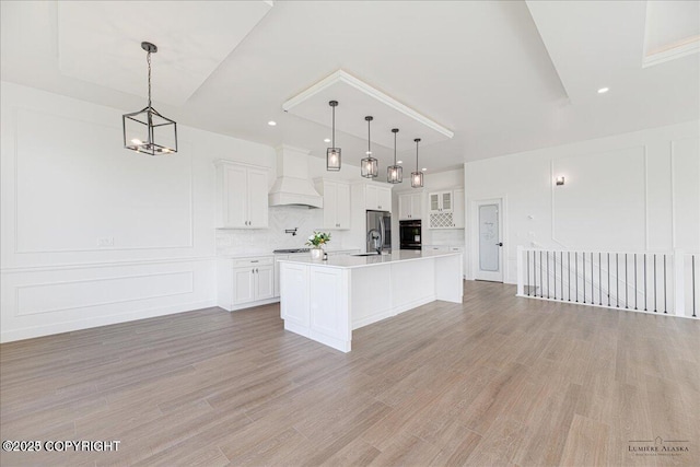 1690 W Valley Ridge Dr, Wasilla, AK 99654 - kitchen with custom range hood, stainless steel fridge, light countertops, backsplash, and white cabinets