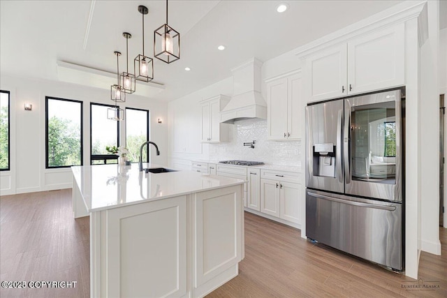 1690 W Valley Ridge Dr, Wasilla, AK 99654 - kitchen with stainless steel fridge with ice dispenser, a sink, gas stovetop, premium range hood, and white cabinetry