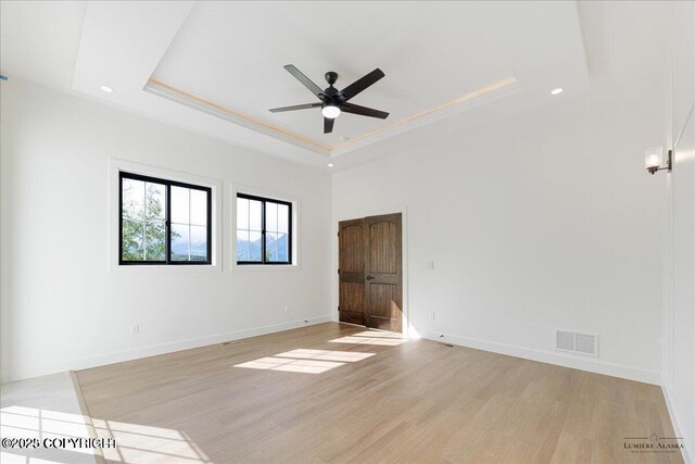 1690 W Valley Ridge Dr, Wasilla, AK 99654 - spare room with a tray ceiling, a ceiling fan, light wood-style flooring, baseboards, and recessed lighting
