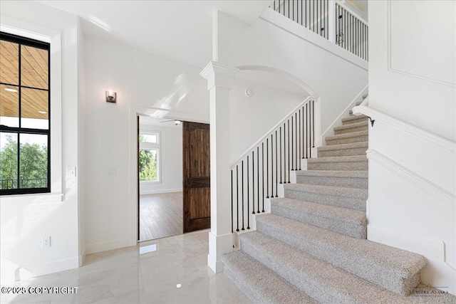 1690 W Valley Ridge Dr, Wasilla, AK 99654 - stairs featuring baseboards, marble finish floors, and decorative columns