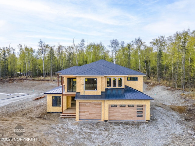 1690 W Valley Ridge Dr, Wasilla, AK 99654 - property in mid-construction with a standing seam roof, metal roof, an attached garage, and a wooded view