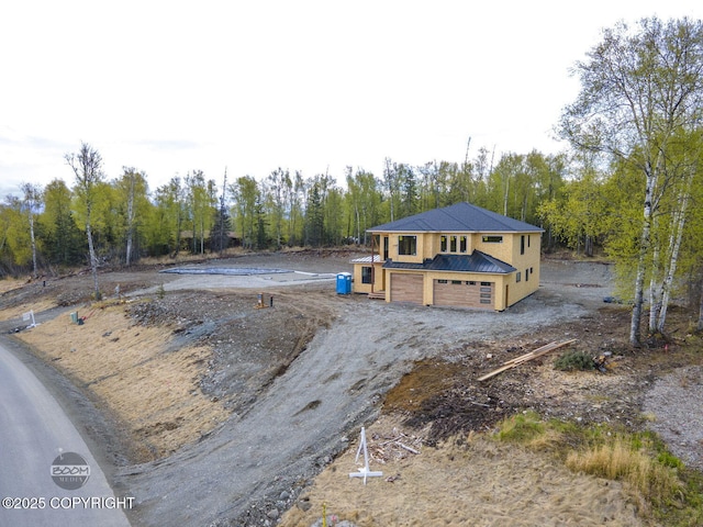 1690 W Valley Ridge Dr, Wasilla, AK 99654 - view of front of property with metal roof, driveway, view of wooded area, and an attached garage