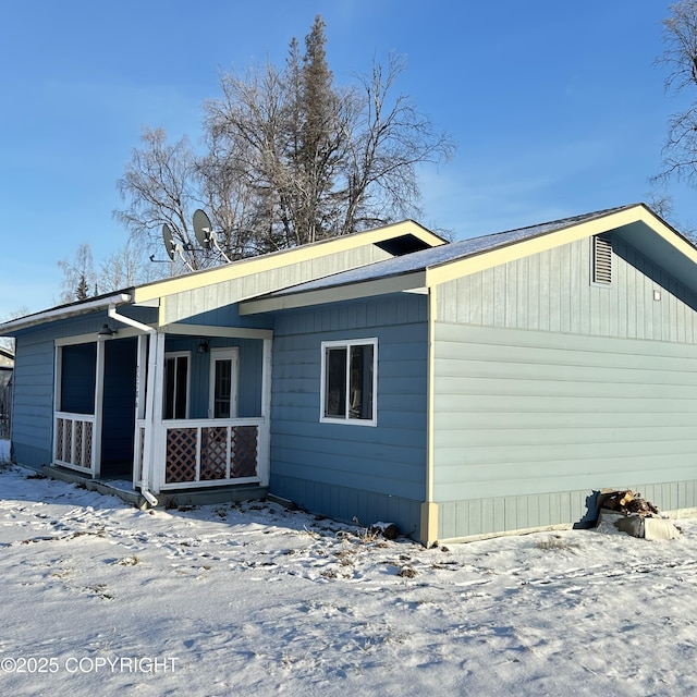 snow covered property featuring covered porch