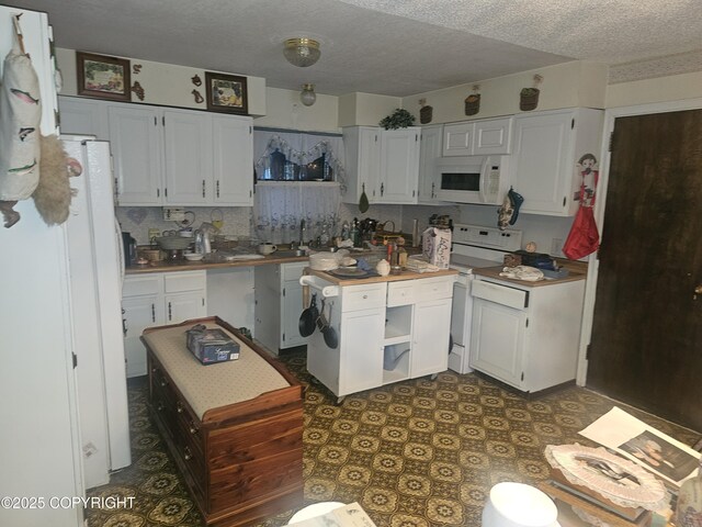 8400 George Ct, Anchorage, AK 99516 - kitchen with white appliances, white cabinets, a textured ceiling, tasteful backsplash, and sink