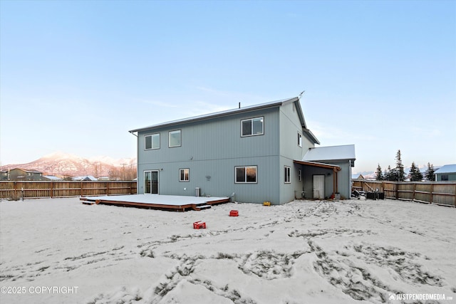 snow covered property featuring a deck with mountain view