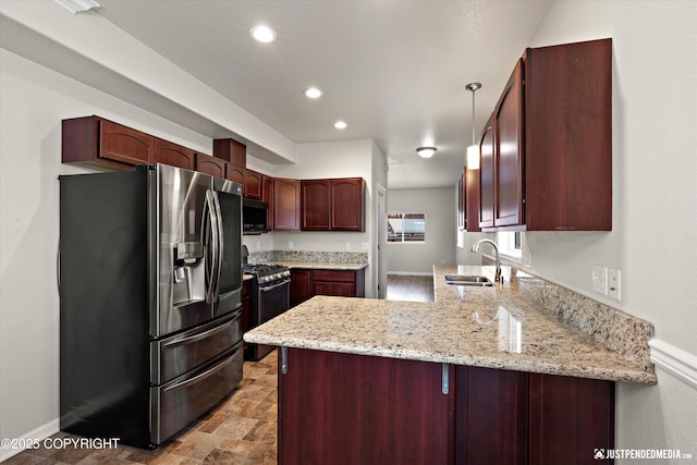 kitchen with pendant lighting, sink, appliances with stainless steel finishes, light stone counters, and kitchen peninsula