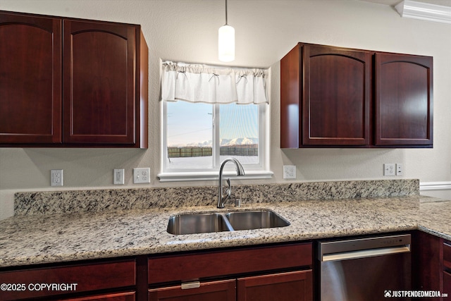 kitchen featuring light stone counters, sink, pendant lighting, and stainless steel dishwasher