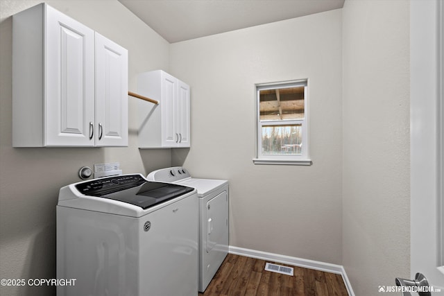 washroom featuring cabinets, dark hardwood / wood-style floors, and washer and dryer