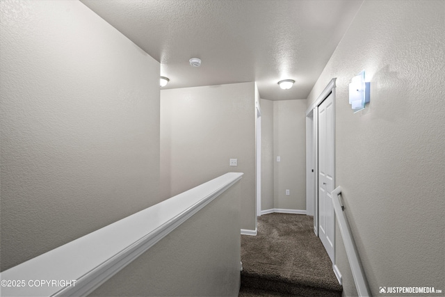 stairway featuring carpet floors and a textured ceiling