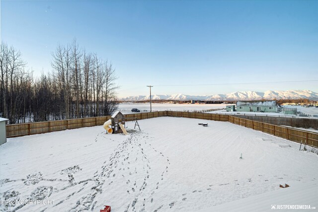 yard layered in snow with a mountain view