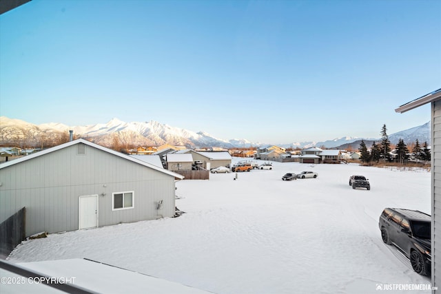 yard covered in snow featuring a mountain view