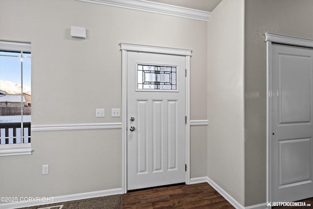 foyer entrance featuring ornamental molding and dark hardwood / wood-style floors