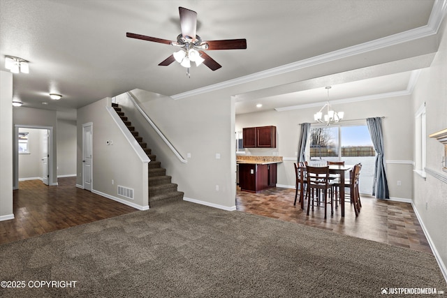 unfurnished dining area featuring crown molding, dark carpet, and ceiling fan with notable chandelier