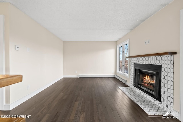 unfurnished living room with dark hardwood / wood-style flooring, a baseboard radiator, a fireplace, and a textured ceiling