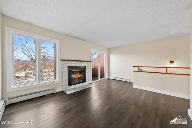 unfurnished living room with dark hardwood / wood-style flooring, a baseboard heating unit, a textured ceiling, and a fireplace