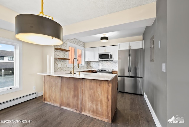 kitchen with decorative light fixtures, tasteful backsplash, white cabinetry, appliances with stainless steel finishes, and sink