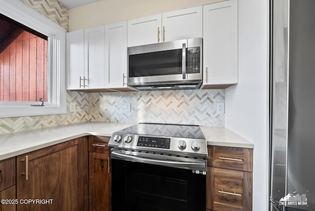 kitchen with white cabinets, stainless steel appliances, and backsplash