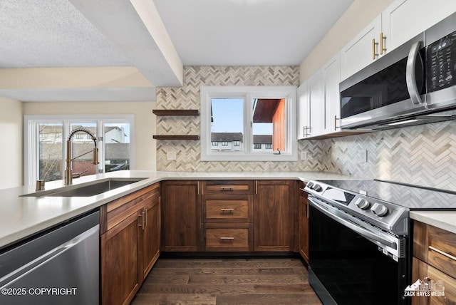 kitchen featuring stainless steel appliances, sink, white cabinets, backsplash, and dark hardwood / wood-style flooring