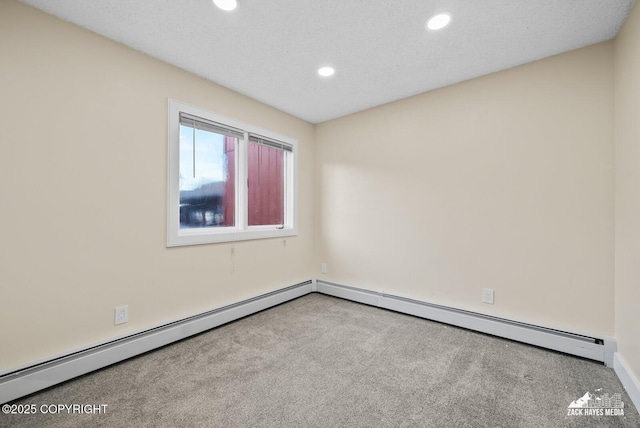 spare room with baseboard heating, light colored carpet, and a textured ceiling