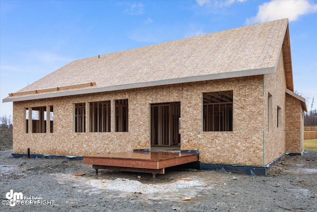 rear view of property featuring a wooden deck