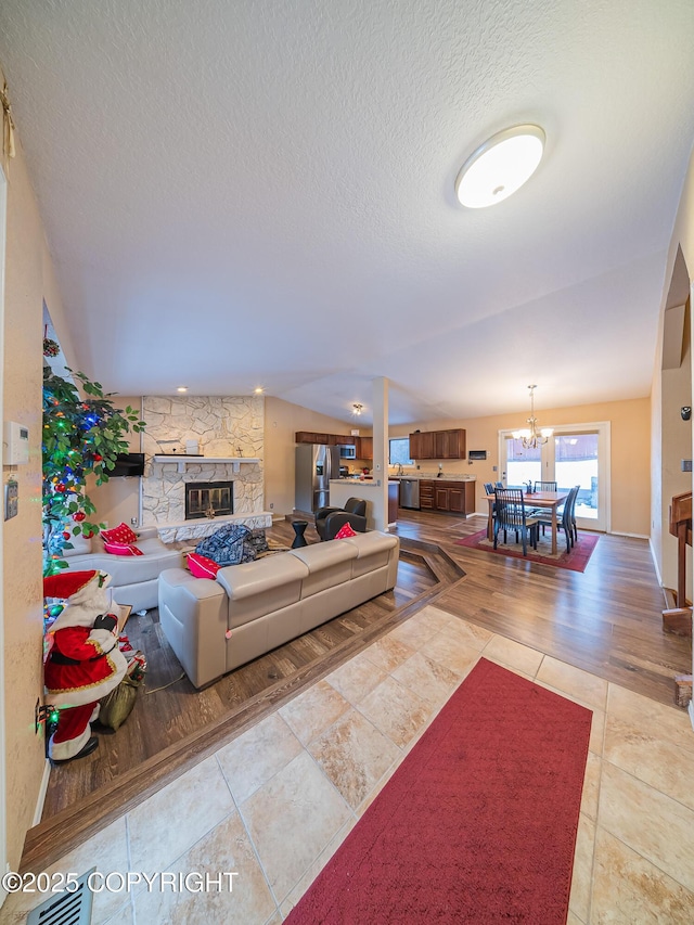 tiled living room featuring a notable chandelier and a fireplace