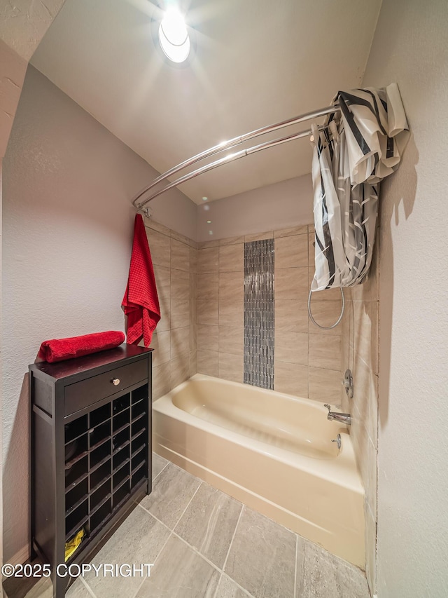 bathroom with tiled shower / bath and tile patterned floors