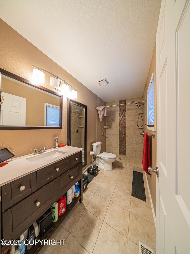 bathroom with tile patterned floors, toilet, a textured ceiling, vanity, and curtained shower