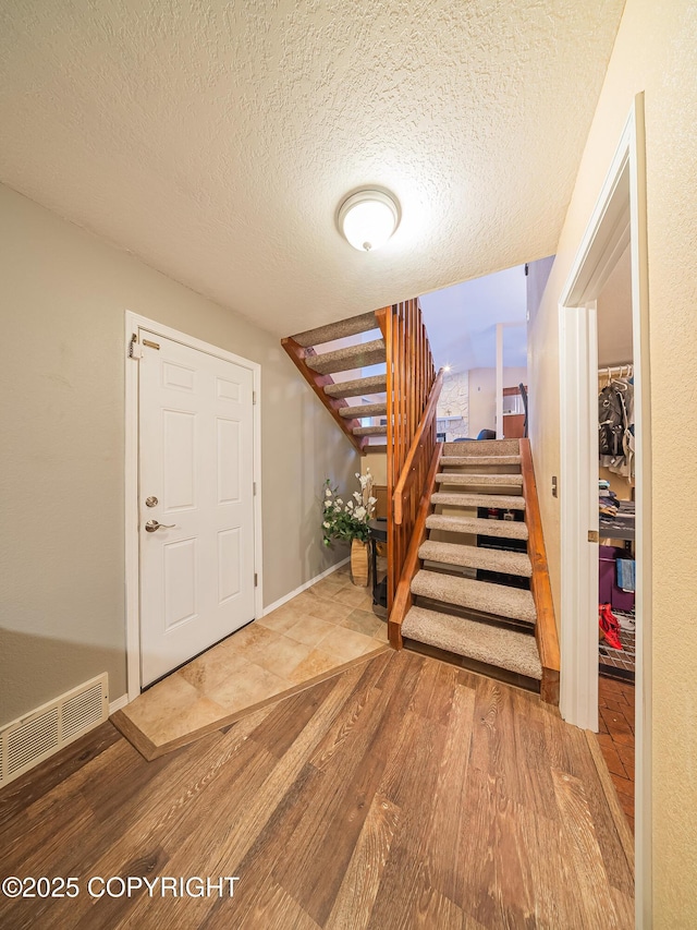 foyer with wood-type flooring and a textured ceiling