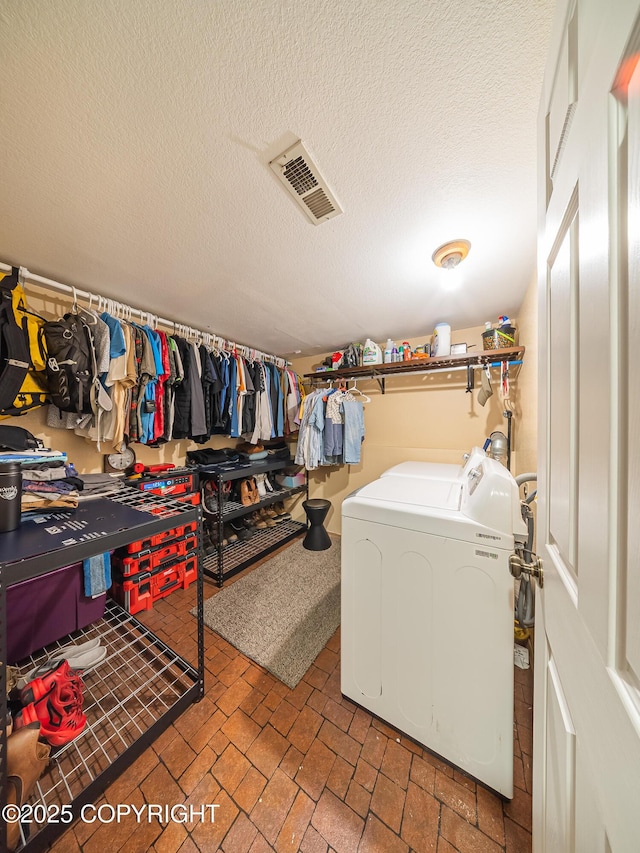 laundry room with washing machine and dryer and a textured ceiling