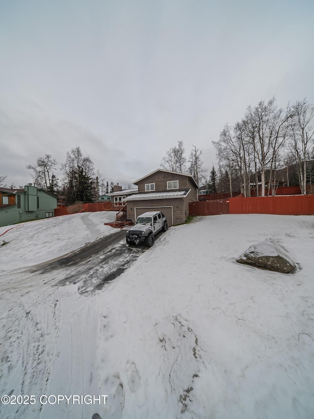 snowy yard featuring a garage