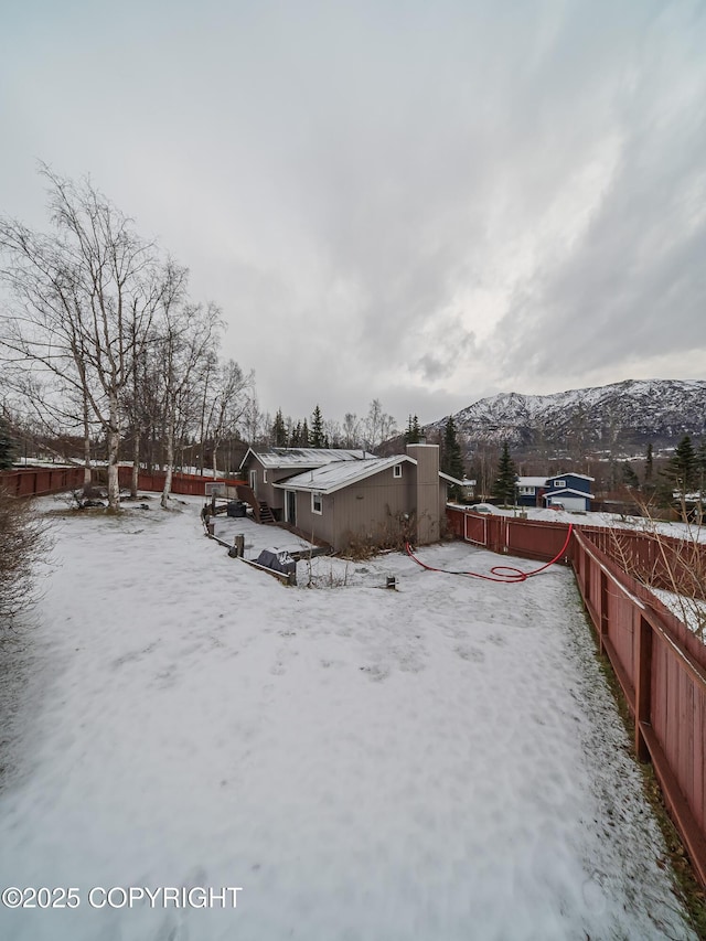 yard covered in snow with a mountain view