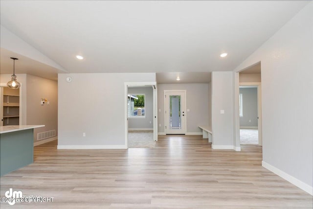 unfurnished living room featuring light wood-type flooring and lofted ceiling