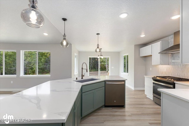 kitchen with sink, tasteful backsplash, a center island with sink, pendant lighting, and appliances with stainless steel finishes