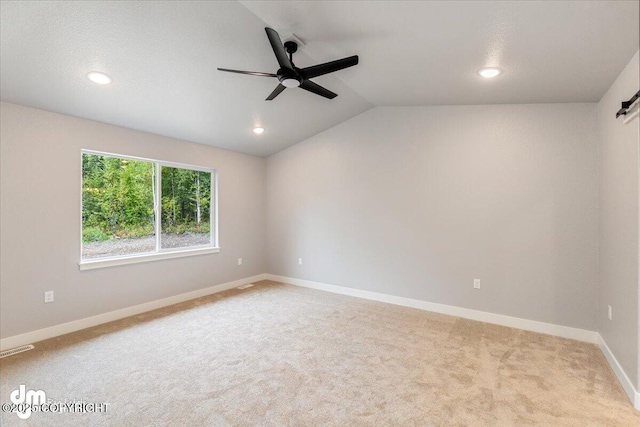 carpeted spare room with a barn door, ceiling fan, and lofted ceiling