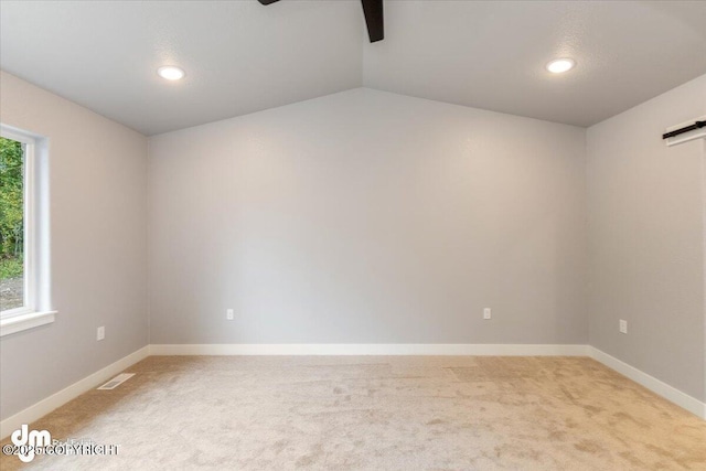 carpeted empty room with vaulted ceiling