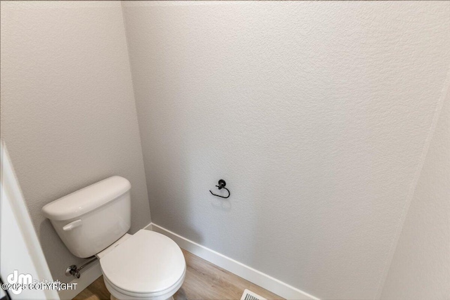 bathroom with toilet and wood-type flooring