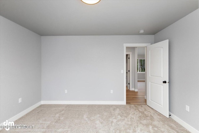 unfurnished room featuring light colored carpet