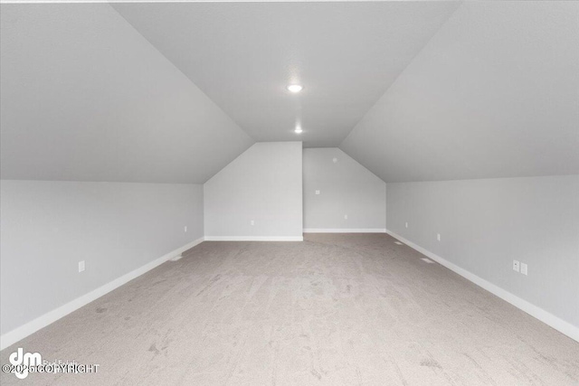 additional living space with lofted ceiling and carpet flooring