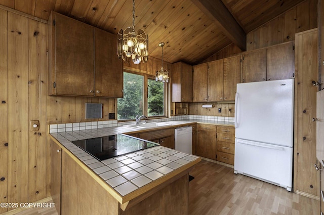 kitchen with white appliances, tile counters, pendant lighting, and sink