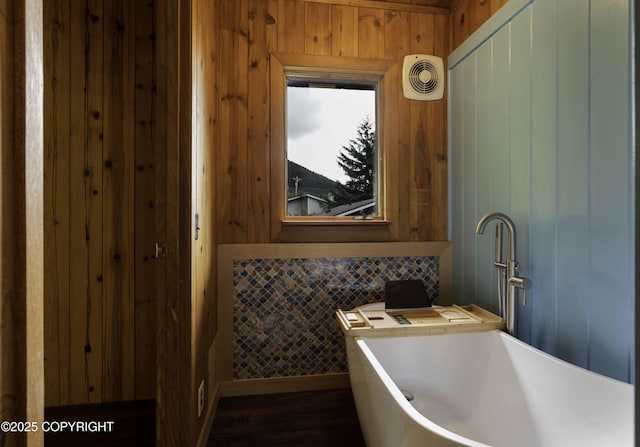 bathroom featuring wooden walls and sink