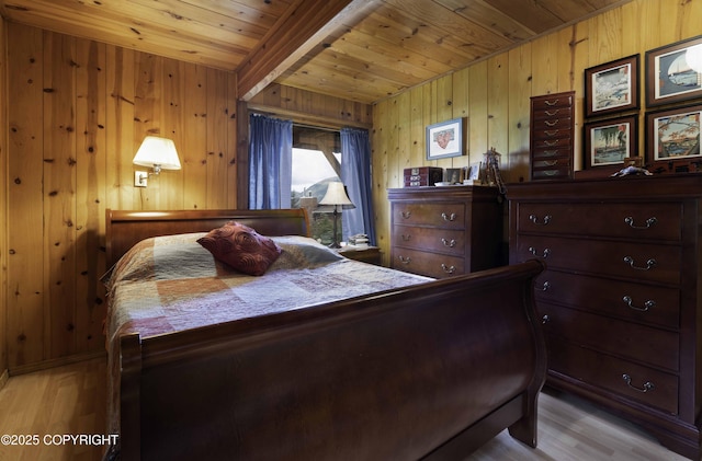 bedroom with light wood-type flooring, wooden walls, and wooden ceiling