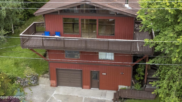 rear view of house with a garage and a wooden deck