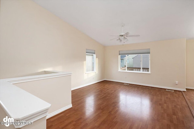 spare room with ceiling fan, dark wood-type flooring, and vaulted ceiling