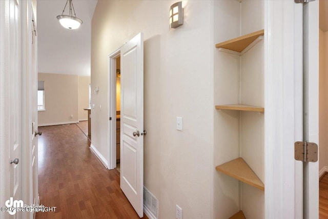 corridor featuring vaulted ceiling and dark wood-type flooring