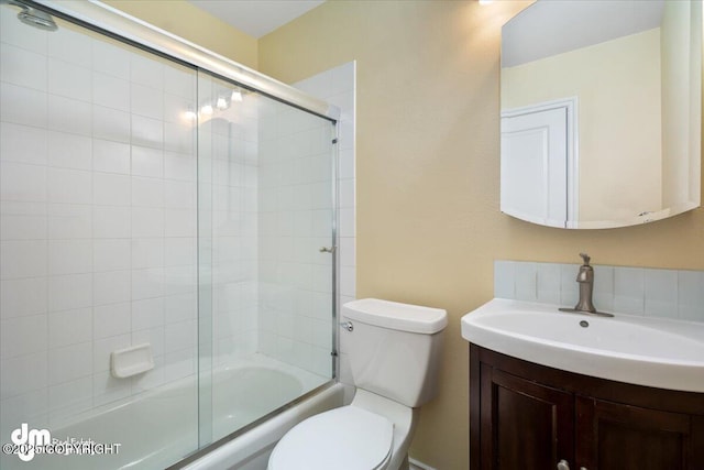 full bathroom featuring toilet, vanity, and bath / shower combo with glass door